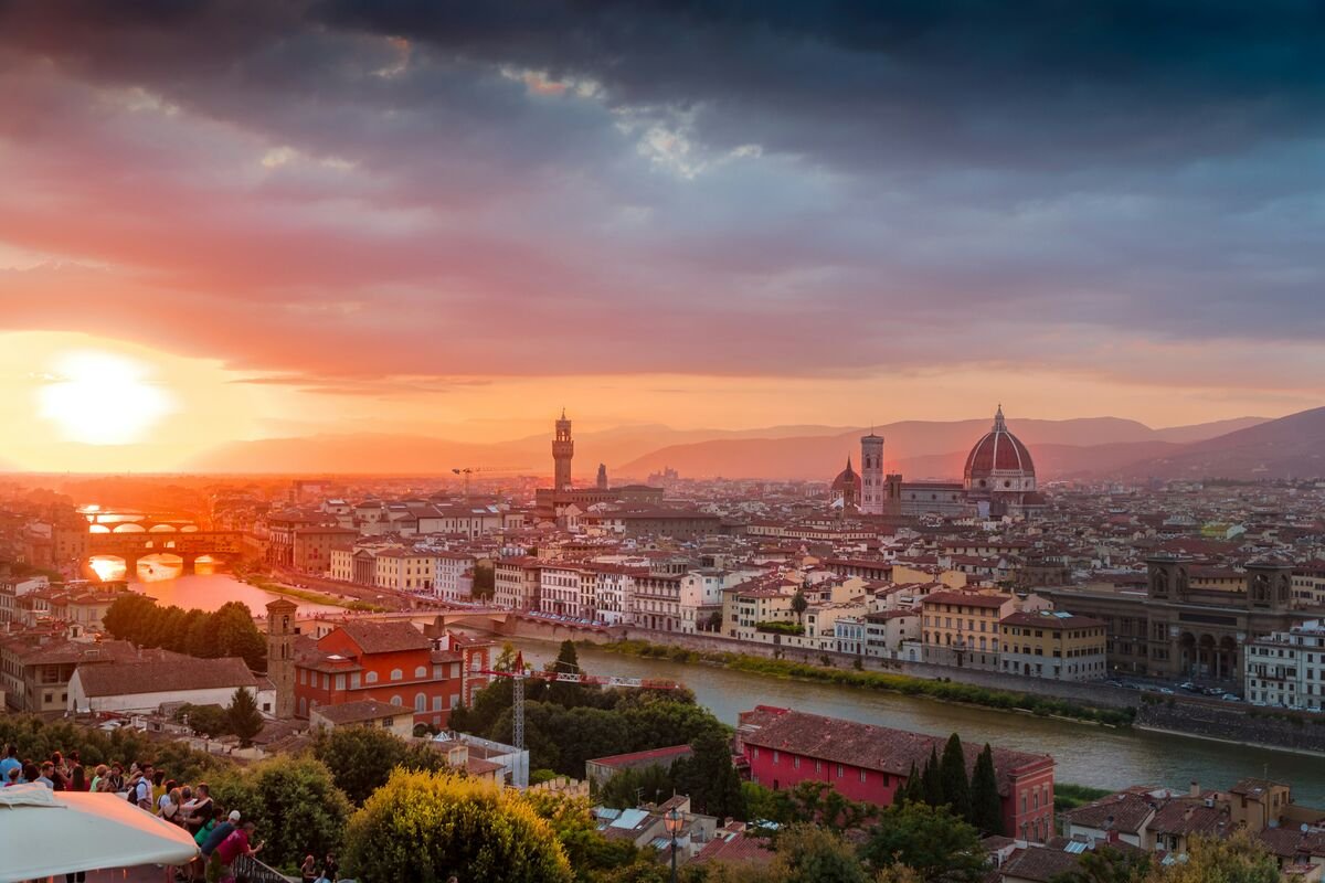 Florence Italy, a beautiful orange sun setting upon Florence's center, with the river Arno, Duomo and Ponte Vecchio glistening